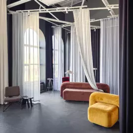 Интерьерная фотостудия с яркой мебелью и очень длинными шторами